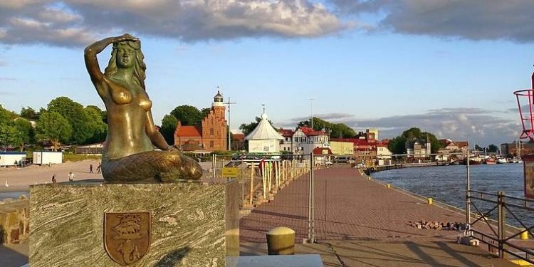 Ustecka syrenka, w tle zabytkowe budynki Ustki